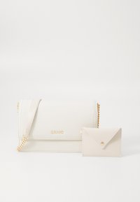 Bolsa transversal em imitação de pele branca com alça de corrente dourada, apresentando uma aba dobrável. Inclui um pequeno porta-cartões bege com fechamento de botão de pressão.