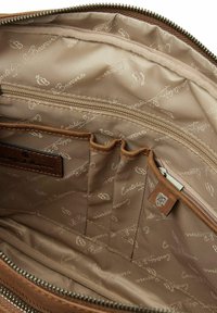 Bruine leren tas met beige voering, voorzien van een ritszak, meerdere vakken en een herhalend logo-patroon, zachte textuur.