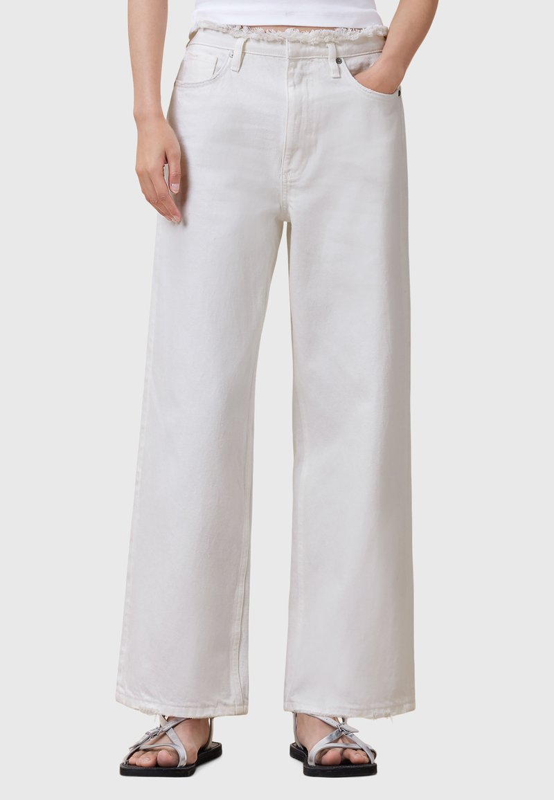 Jeans de mezclilla blanca de pierna ancha con una textura suave, que cuentan con un cierre de botón, bolsillos laterales y detalles de dobladillo deshilachado.