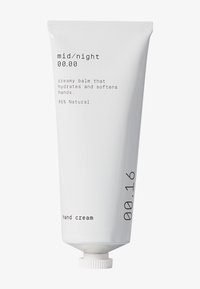 Vit tub med handkräm med matt yta, med minimalistisk svart text. Innehåller detaljer som "krämig salva" och "95 % naturlig."