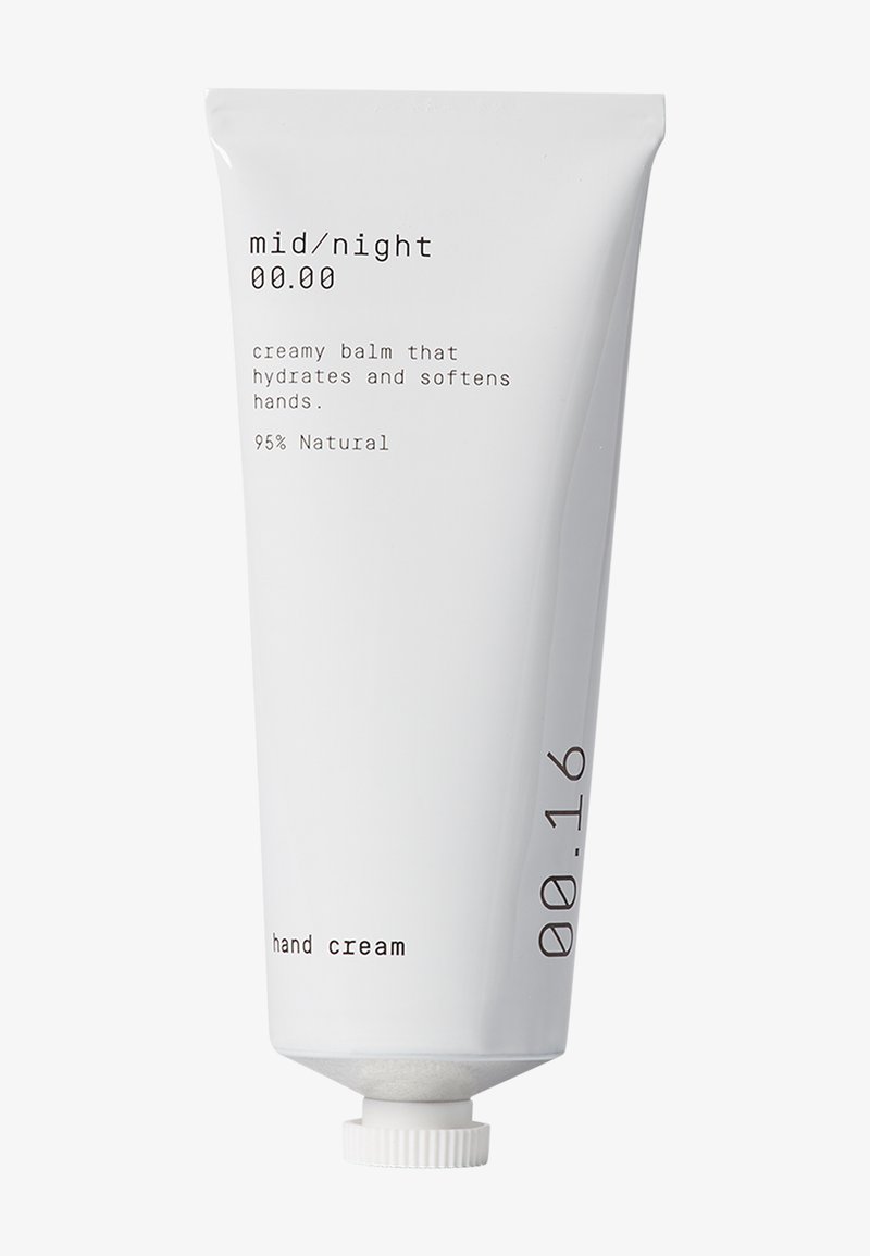 Hvit tube med håndkrem med en matt finish, med minimalistisk svart tekst. Inneholder detaljer som "kremet balsam" og "95 % naturlig."