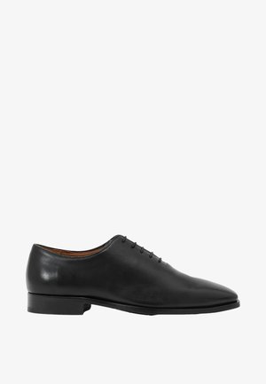 Zapato Oxford formal de hombre de cuero negro con cordones cerrados y tacón bajo, mostrado en perfil lateral sobre fondo blanco.