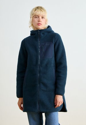 Donkerblauwe fleece jas met capuchon, volledige ritssluiting aan de voorkant en een borstzak. Heeft een gestructureerd oppervlak en een langere achterkant.