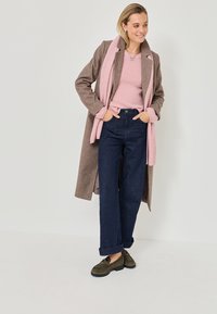 Brun ullblandad kappa, ljusrosa tröja, marinblå vida jeans och mörkgröna snörskor. Scarfen är ljusrosa med ribbad textur.