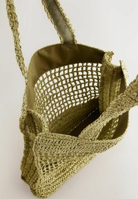 Borsa di paglia intrecciata in verde oliva con un design a maglia aperta, fodera in tessuto morbido e lunghi manici testurizzati per un trasporto confortevole.