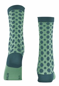 Grüne gemusterte Socken mit dunkelgrünen Punkten, einer verstärkten Spitze und einem kontrastierenden dunkelgrünen Bündchen. Hergestellt aus weichem Stoff.