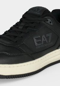 Μαύρο δερμάτινο αθλητικό παπούτσι EA7 Emporio Armani με μαύρα κορδόνια και λευκή σόλα, με το λογότυπο της μάρκας στο πλάι και στη γλώσσα.