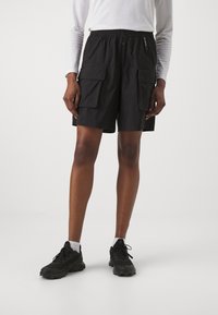 Svarta cargoshorts i lättviktig material med elastisk midja, två framfickor och en avslappnad passform. I kombination med svarta löparskor.