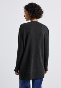 Donkergrijze gebreide cardigan met lange mouwen, geribbelde manchetten en een rechte zoom. Zachte textuur en een relaxte pasvorm voor comfort.