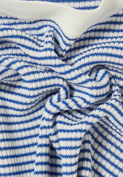 Tessuto di maglia bianco con righe blu, caratterizzato da una texture morbida. Il materiale è spiegazzato, mostrando intricati motivi e un colletto a contrasto.