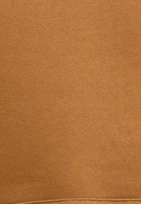 Καμμένο πορτοκαλί ύφασμα με λεία υφή, που διαθέτει ένα μαλακό, ενιαίο χρώμα και μια διακριτική γυαλάδα. Έχει έναν καθαρό, χωρίς διακοσμήσεις σχεδιασμό.