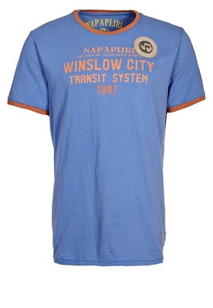 Blaues T-Shirt mit kurzen Ärmeln und orangem Rand, mit dem Schriftzug „Napapijri Winslow City Transit System 1987“ und einem runden Aufnäher auf der Brust.