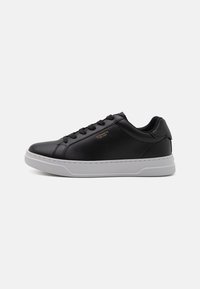 Sneaker din piele neagră cu un design de șireturi cu model, talpă din cauciuc alb și branding subtil pe laterale. Textură netedă pe întreaga suprafață.