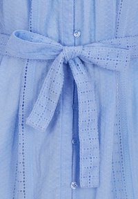 Robe bleu clair en tissu texturé avec un motif en grille. Comprend une ceinture nouée à la taille et des boutons le long du devant.
