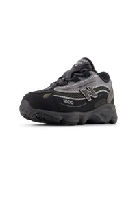 Αθλητικό παπούτσι σε μαύρο και γκρι χρώμα με πάνω μέρος από δίχτυ, επενδυμένο γιακά, διακριτικό λογότυπο "N" και υφασμένο καουτσούκ με βαθύ προφίλ στην σόλα.