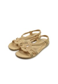 Sandalias de cuerda beige con tiras cruzadas, suelas texturizadas y un detalle de nudo. Diseño ligero adecuado para uso casual.