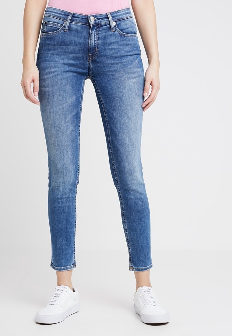 Blå tightjeans med medelhög midja och femficksdesign. Tyget har en jämn textur och har lite blekning på låren.