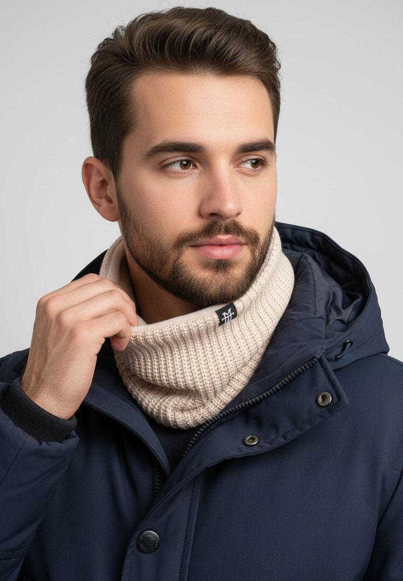 Beige knitted neck warmer with a ribbed texture, worn under a navy blue jacket with a hood, featuring a small black logo on the fabric.