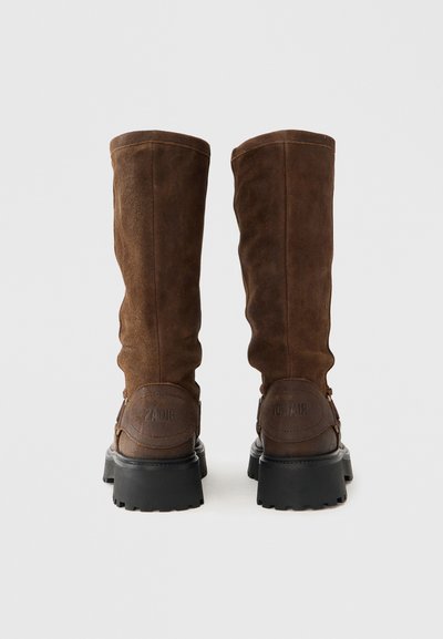 Καφέ σουέτ μπότες μέχρι το γόνατο με υφή, παχιά μαύρη λαστιχένια σόλα και ανάγλυφο λογότυπο στη φτέρνα.