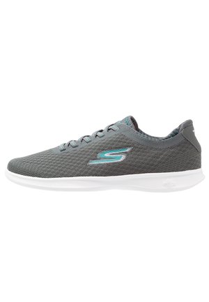 Gray mesh athletic sneaker with teal detail "S" logo, white sole, and lace-up design, shown from the outer side.