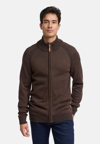 Brun hættetrøje med lynlås, ribbet krave og manchetter. Har en glat tekstur og kontrastsyninger langs skuldersømmene.