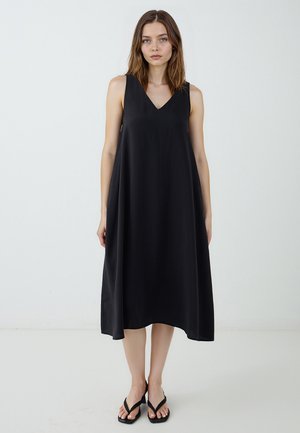 Abito nero senza maniche con scollatura a V, silhouette ad A, realizzato in un tessuto morbido, caratterizzato da un orlo lungo e un design minimalista.