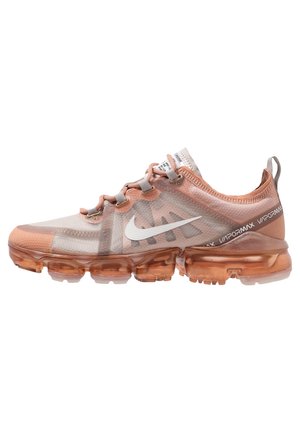 Baskets Nike Vapormax rose clair avec semelle bulle orange translucide, logo swoosh blanc et texte "Vapormax" sur la languette du talon.
