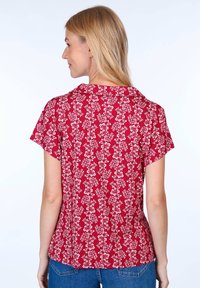 Red short-sleeve blouse featuring a floral pattern, collared design, and a relaxed fit, made of lightweight fabric.