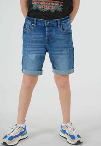 Shorts en jean, bleu moyen avec une légère décoloration et des ourlets roulés ; dotés de poches avant et arrière avec un détail de fermeture à bouton.