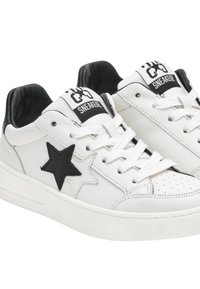 Sneakers bianchi in pelle con decorazioni a forma di stella nera, accenti neri sul tallone e logo nero sulla linguetta. Presentano lacci bianchi e punta perforata.
