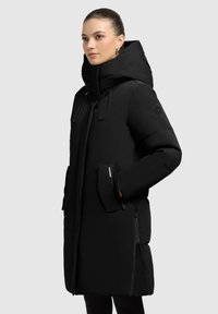 Black puffer jacket with a hood, featuring drawstrings, zippered pockets, and a smooth exterior texture. Slim fit design with insulation.