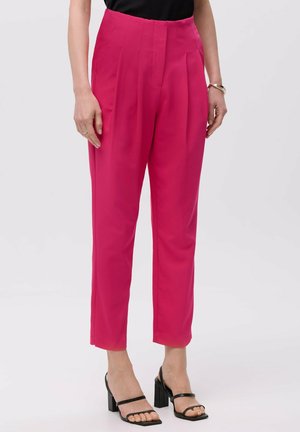 Fuchsia high-waisted trousers with pleats, straight legs, and a smooth texture. Paired with black block-heeled strappy sandals.