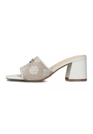 Mule beige aperti con tacco presentano una tomaia texturizzata, bordi bianchi e motivi geometrici. Il tacco a blocco è bianco con una base marrone.