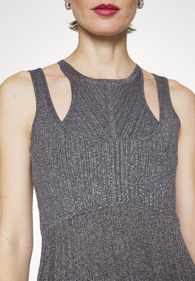 Ujjatlan szürke ruha bordázott textúrával, kivágott vállakkal és testhezálló felső résszel, amely a dereknál bővül.