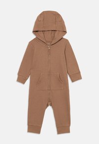 Brown ribbed onesie with a zip front, long sleeves, and a hood featuring small bear ears. Includes two front pockets and fitted cuffs.