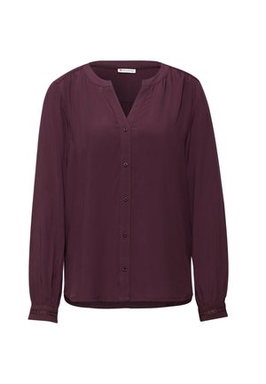 Camisa de manga larga con escote en V en tejido burdeos intenso, con cierre de botones y acentos decorativos en los puños. Textura suave, diseño ligero.