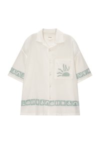 Camisa de manga corta, blanca, con cierre de botones, que presenta un diseño gráfico verde y un bolsillo con una impresión de sol. Tejido texturizado.