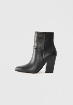 Black leather ankle boot with a pointed toe, smooth texture, wide block heel, and a folded design detail at the top.