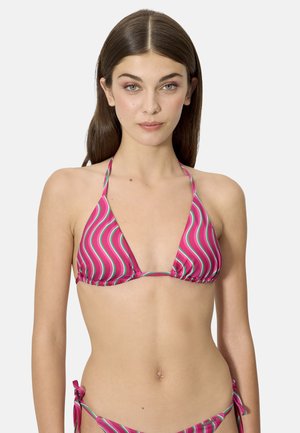 Mujer con cabello largo y castaño, vistiendo un top de bikini halter con rayas onduladas en rosa y verde y bragas a juego con lazos a los lados, mirando hacia adelante.
