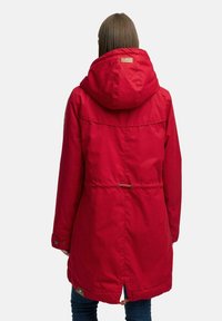 Parka impermeabile rossa con grande cappuccio, vita cintrata e polsini con bottoni. Tessuto liscio, ventola posteriore e dettaglio del logo.