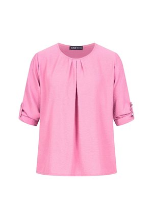 Blusa rosa a maniche corte con scollo rotondo, caratterizzata da una piega frontale e maniche arrotolate fissate con bottoni. Tessuto strutturato.