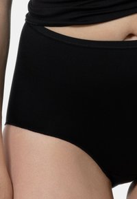 Mutande nere a vita alta realizzate in un tessuto liscio ed elastico. Presentano un design semplice senza motivi visibili o hardware.