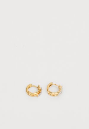Boucles d'oreilles en or en forme d'anneau avec une finition lisse, ornées d'une petite rangée de gemmes claires d'un côté pour une touche de détail supplémentaire. Forme ronde, design léger.