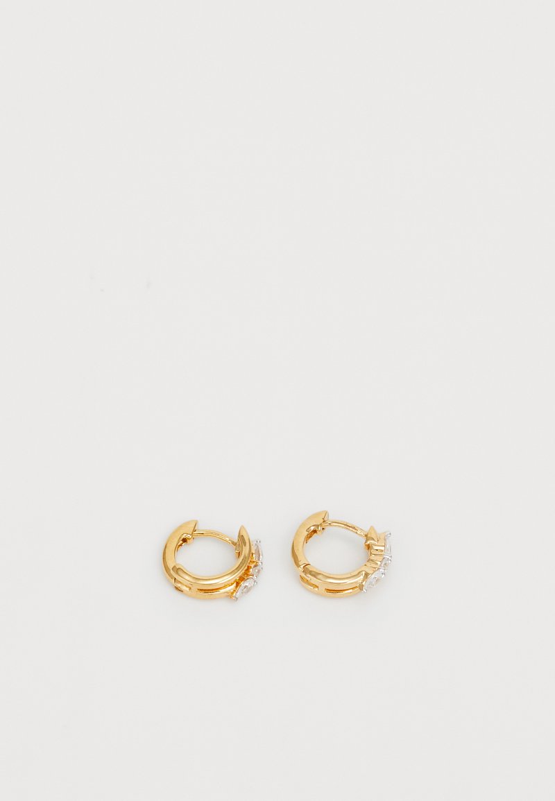 Boucles d'oreilles en or en forme d'anneau avec une finition lisse, ornées d'une petite rangée de gemmes claires d'un côté pour une touche de détail supplémentaire. Forme ronde, design léger.