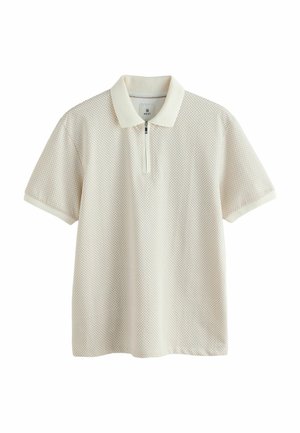 Korte mouwen polo in lichtbeige met een textuurpatroon, ritskraag en ribgebreide afwerking. Het materiaal lijkt ademend en lichtgewicht te zijn.
