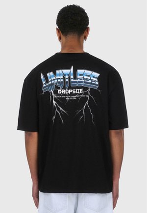 Čierne bavlnené tričko so žiarivým modrým grafickým nápisom "LIMITLESS" na chrbte, ktorý je doplnený bleskovými motívmi a slovom "DROPSIZE."