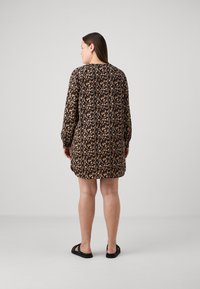 Μαύρο φλοράλ φόρεμα με μακριά μανίκια, διαθέτει άνετη εφαρμογή και στρογγυλή λαιμόκοψη. Το σχέδιο περιλαμβάνει ροζ και κρεμ λεπτομέρειες, με απαλή υφή υφάσματος.