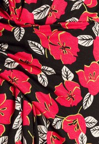 Svart tyg med ljusa röda blommor och vita blad, med gula konturer och lätt veck i materialet.