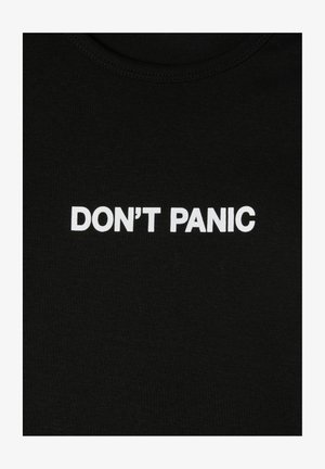Czarna bawełniana koszulka z białym napisem "NIE PANIKUJ." Okrągły dekolt, gładka tekstura, prosty design.