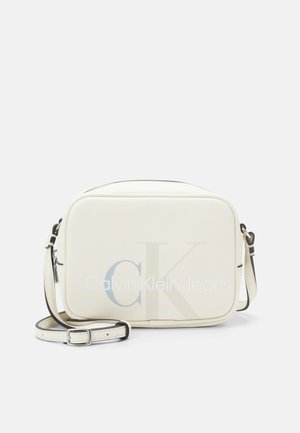 White rectangular crossbody bag with adjustable strap and "Calvin Klein Jeans" logo on front.